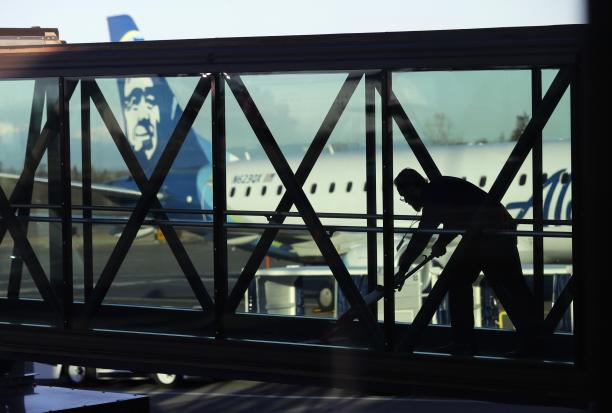 A worker cleans a skybridge before passengers boarded an Alaska Airlines flight to Portland Oregon at Paine Field in Everett Washington