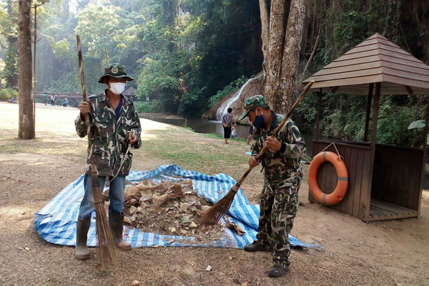 Park rangers collect dry leaves in a bid to stop a forest fire spreading in Phu Sang National Park in Phayao province on Thursday. (Photo by Sai-arun Pinaduang)