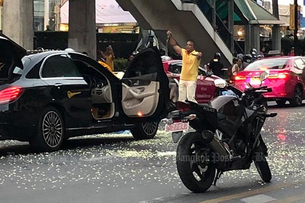 A man holds a cobra and knife in the middle of Ratchadamri Road outside the CentralWorld shopping centre on Wednesday. (Photo by @annniex_ via @js100radio Twitter account)