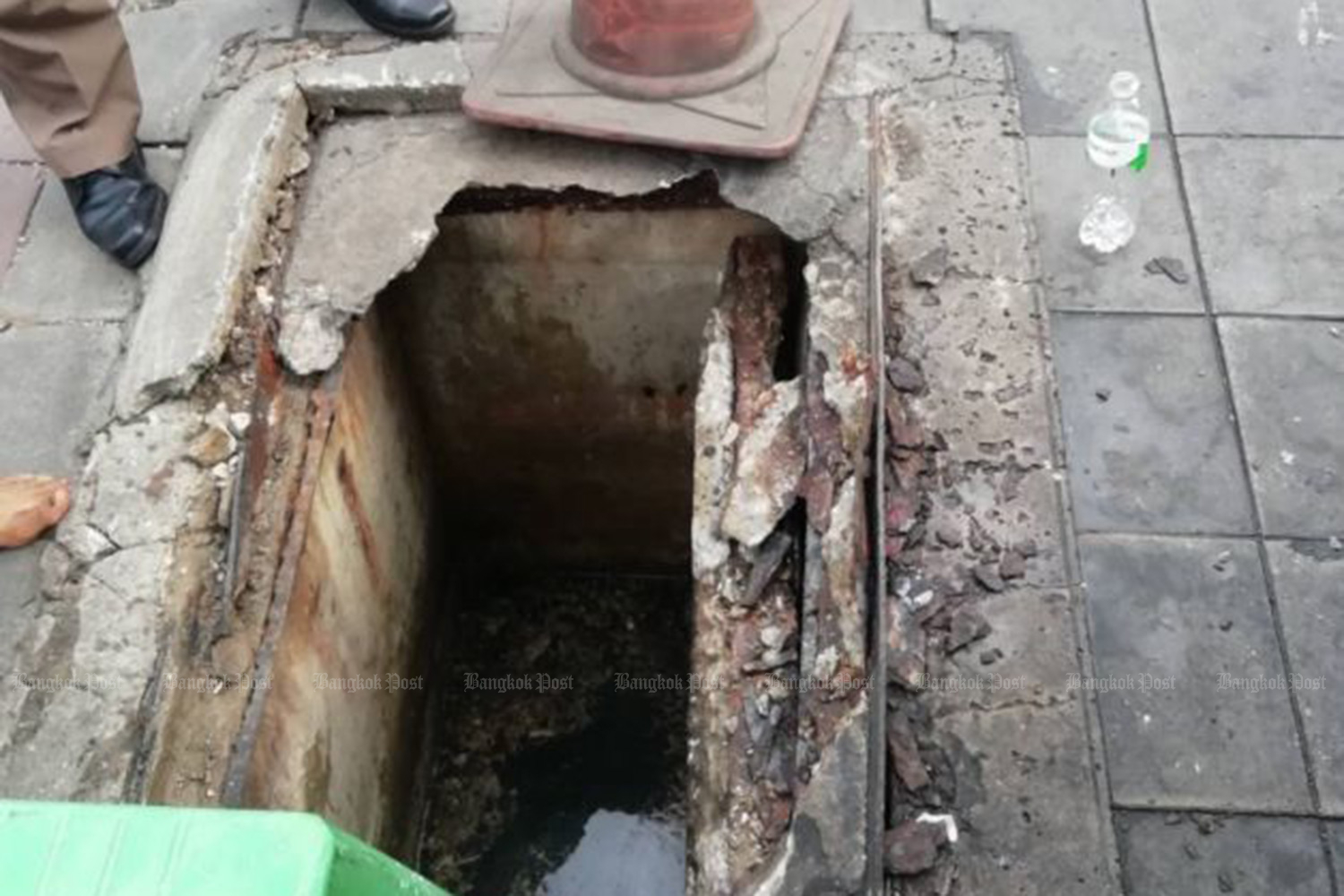 What's left of the cover of the manhole into which a young woman fell in front of the MRT Ratchadaphisek station in Bangkok on Tuesday morning. She was rescued with injuries and bruises on her body. (Photo taken from www.js100.com)