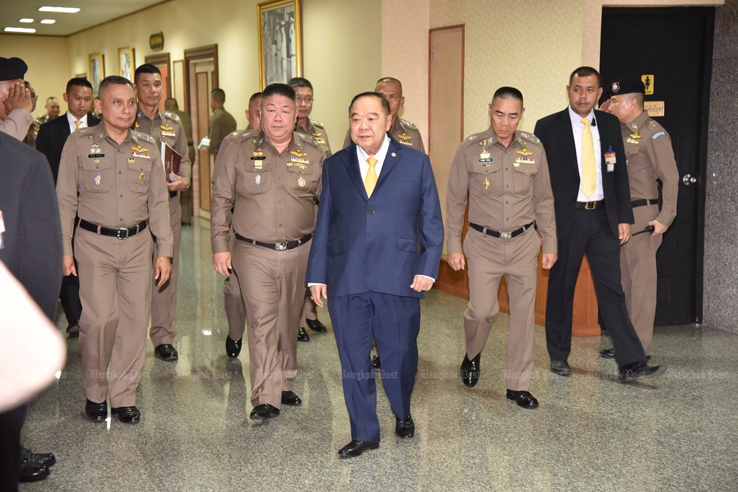 Deputy Prime Minister Gen Prawit Wongsuwon, centre, emerges from a meeting of the Police Commission on Wednesday with national police chief Pol Gen Chakthip Chaijinda, third from right, and Pol Gen Wirachai Songmetta, deputy national police chief, left. (Photo by Wassana Nanuam)