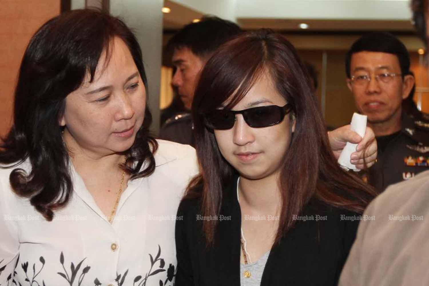 Orachorn “Praewa” Thephasadin na Ayudhya, right, escorted by her mother, reports to police in January 2011 to acknowledge charges of reckless driving over the deadly tollway crash. (Photo by Pattanapong Hirunard)