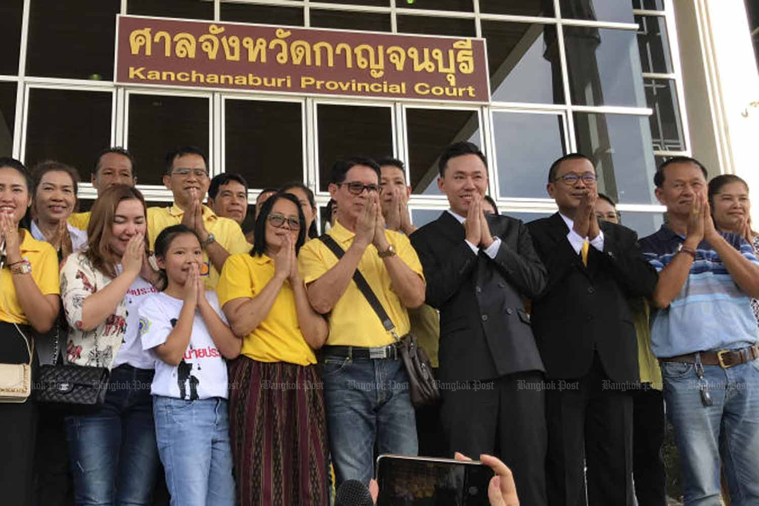 Retired Pol Lt Charoon Wimool, with shoulder bag, and supporters express their gratitude after the Kanchanaburi Court ruled in his favour on June 4, confirming his ownership of lottery tickets that won prizes totalling 30 million baht. (Photo by Piyarach Chongcharoen)