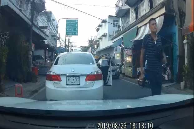 A man is seen carrying a gun after getting out of his car on a road in Bang Kruai district of Nonthaburi on Friday evening. (Screenshot from Tum Natawit Facebook account's clip)