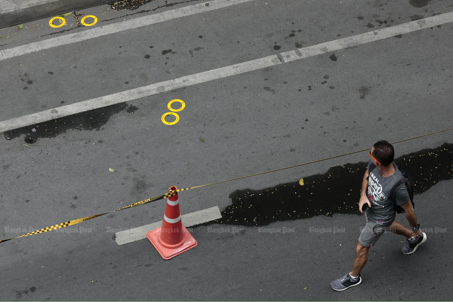 A man walks past a scene where a bomb went off near Chong Nonsi BTS station in Bangkok on Aug 2. (Photo by Patipat Janthong)