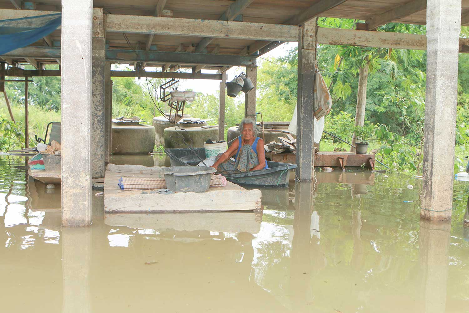 A woman uses a small boat to get around her flooded village in Chum Saeng district of Nakhon Sawan province on Monday. (Photo by Chalit Phumpuang)