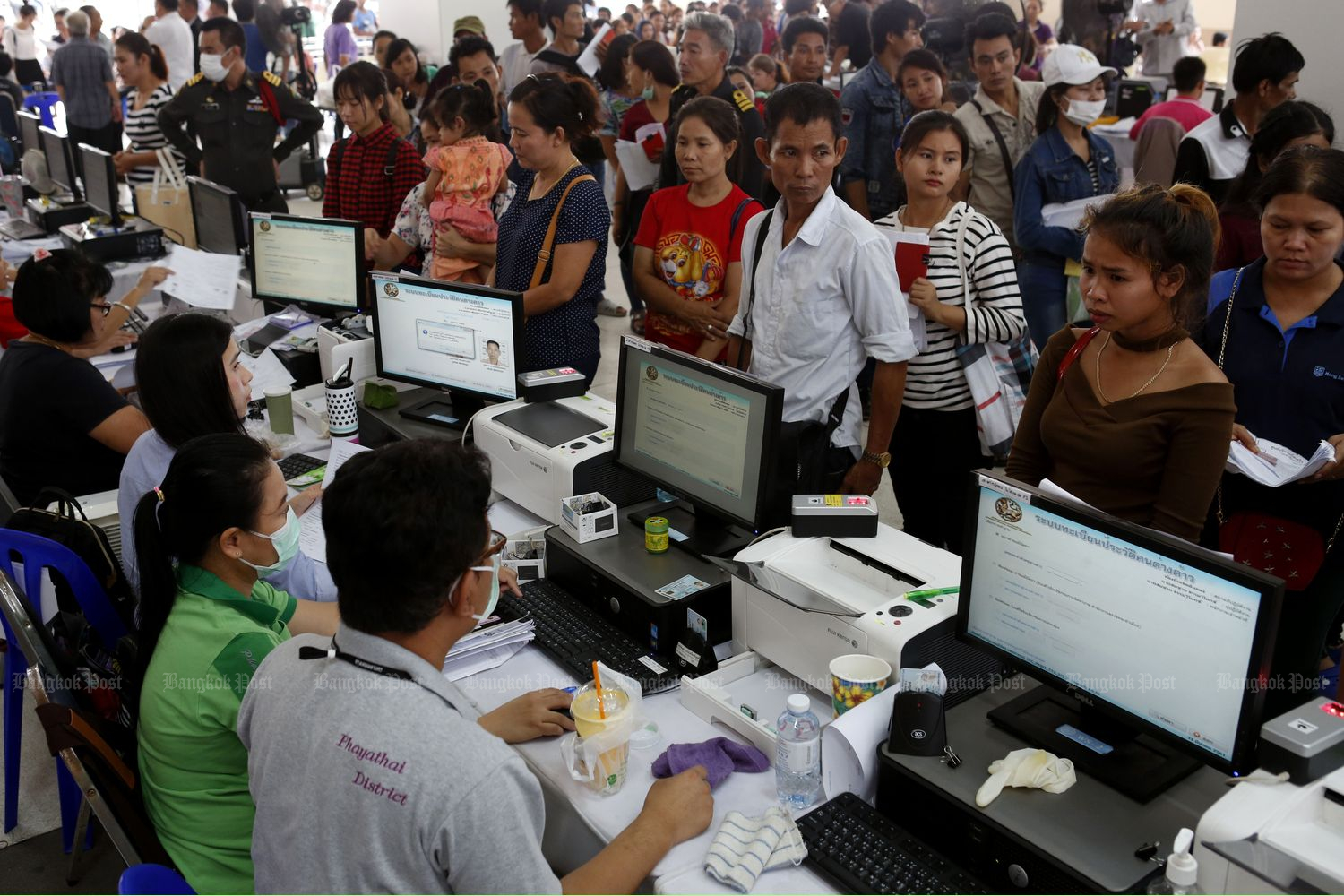 Migrant workers queue at the Labour Ministry in Bangkok ahead of a recent deadline for registration in March last year. (Photo by Pattarapong Chatpattarasill)