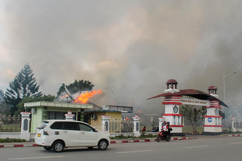 A car passes the governor's office building in Jayawijaya burned during a protest in Wamena, Papua, Indonesia, on Mondah. (Antara Foto/Marius Wonyewun/ via REUTERS)