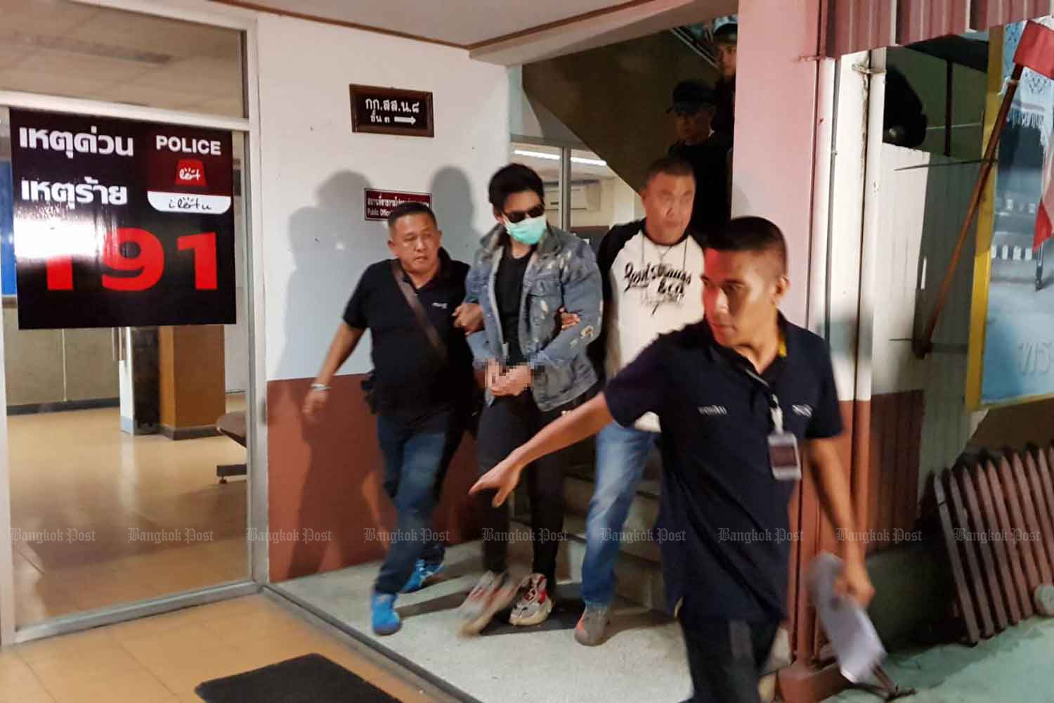 Police escort Rachadech Wongtabutr, 25, into a room at Metropolitan Police Division 8 in Bangkok early Wednesday morning after his arrest in relation to the death of product presenter Thitima 