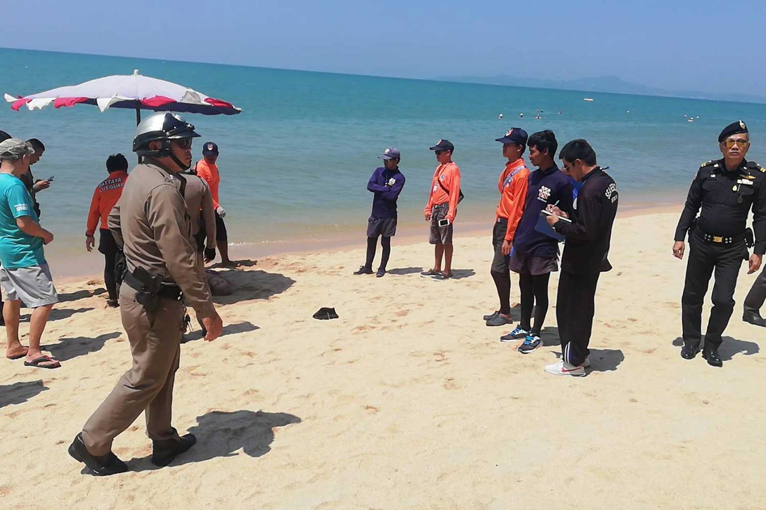 Police with the body of the Kazakhstani woman, 78, at Jomtien beach, near  Pattaya town, in Chon Buri on Thursday morning. (Photo by Chaiyot Pupattanapong)