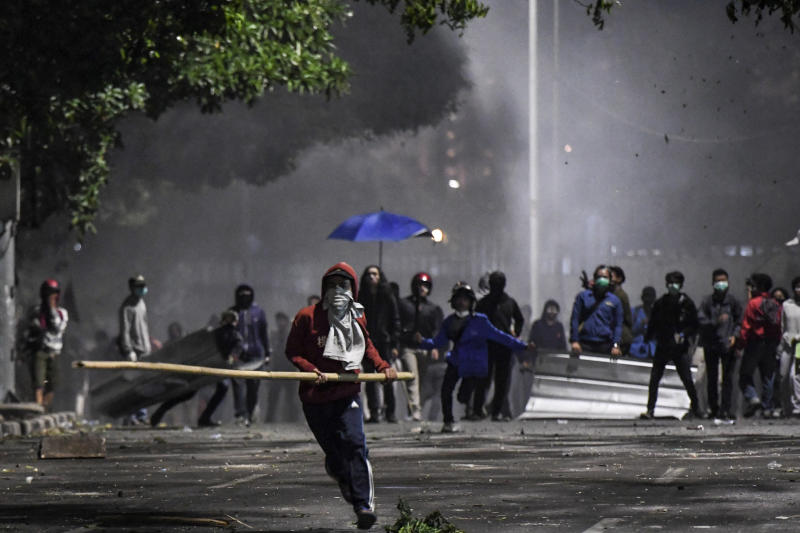 A protester carries a bamboo stick during clashes with police at a riot, following protests near the Indonesian Parliament building, in Jakarta, Indonesia, Sept 30, 2019. (Antara Foto/Hafidz Mubarak A/via REUTERS)