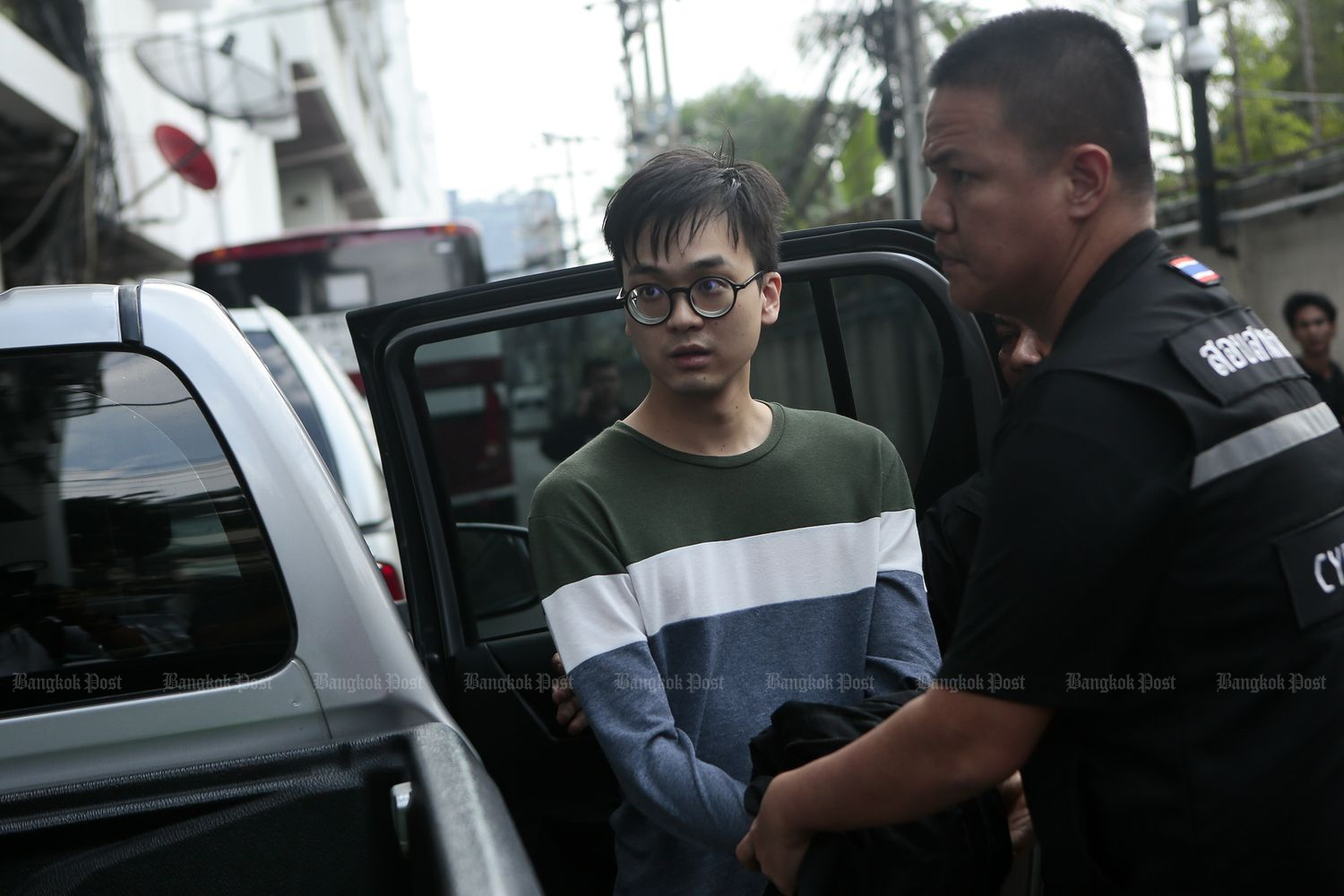 Karn Pongpraphapan, a pro-election activist, is brought to the Criminal Court in Bangkok as police seek to detain him on computer crime charges involving national security. (Photo by Patipat Janthong)