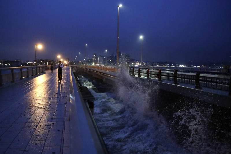 A man walks along the bridge connecting to Enoshima Island in Fujisawa, west of Tokyo, on Friday, as Typhoon Hagibis approaches the area. (AP photo) A man walks along the bridge connecting to Enoshima Island in Fujisawa, west of Tokyo, on Friday, as Typhoon Hagibis approaches the area. (AP photo)