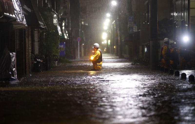 A firefighter makes his way through a flooded street in the residential area in Tokyo hit by Typhoon Hagibis on Saturday.(Kyodo News via AP photo) A firefighter makes his way through a flooded street in the residential area in Tokyo hit by Typhoon Hagibis on Saturday.(Kyodo News via AP photo)