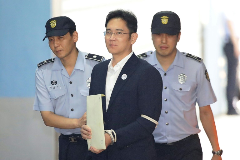 Samsung Group heir Lee Jae-yong arrives at Seoul Central District Court in handcuffs during his trial in 2017. Samsung Group heir Lee Jae-yong arrives at Seoul Central District Court in handcuffs during his trial in 2017.