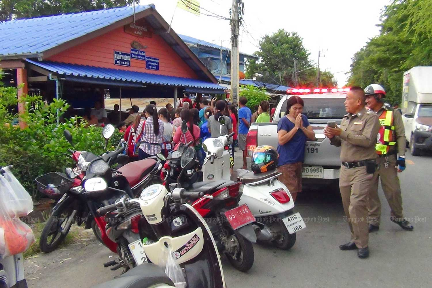 People gather in front of the kamnan's house in tambon Tha Khai in Muang district of Chachoengsao. The local leader was shot and seriously wounded by his wife, who also killed herself. (Photo by Sonthanaporn Inchan)