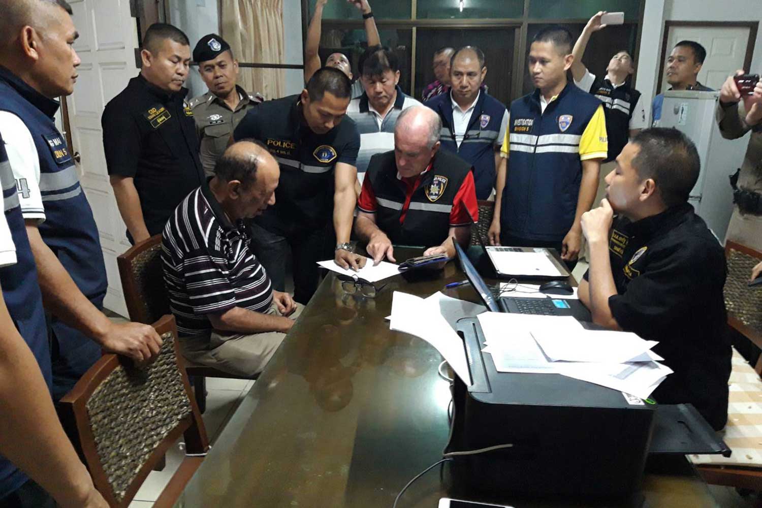 American national Bruce Michael Fein, 75, seated left, is questioned by Crime Suppression Division police with the assistance of an interpreter, centre. (Crime Suppression Division photo) American national Bruce Michael Fein, 75, seated left, is questioned by Crime Suppression Division police with the assistance of an interpreter, centre. (Crime Suppression Division photo)