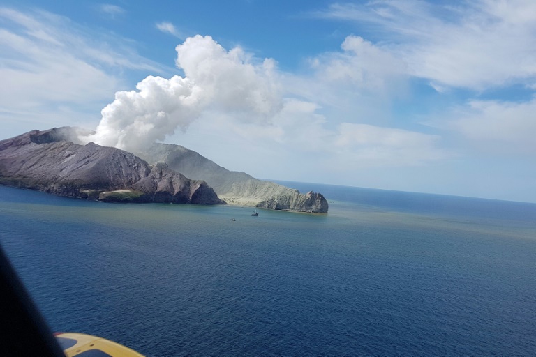 This handout photo taken on Dec 9, 2019 and released by the Auckland Rescue Helicopter Trust shows the view as a helicopter heads toward the smoldering White Island volcano off the coast of New Zealand's North Island. This handout photo taken on Dec 9, 2019 and released by the Auckland Rescue Helicopter Trust shows the view as a helicopter heads toward the smoldering White Island volcano off the coast of New Zealand's North Island.