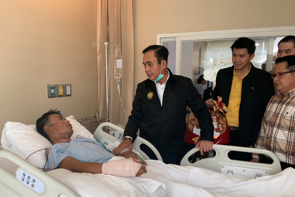 Prime Minister Prayut Cha-o-cha visits an injured man at Maharat Nakhon Ratchasima Hospital on Sunday. — Government House via Reuters