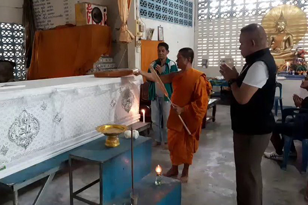 A monk leads the cremation rite for Roger Smith, with Thung Yai police chief Pol Col Chokdee Rakwattanapong among the attendees, at Artapikhirikhet forest monastery in Thung Yai district of Nakhon Si Thammarat province on Monday. (Photo by Nujaree Raekrun)