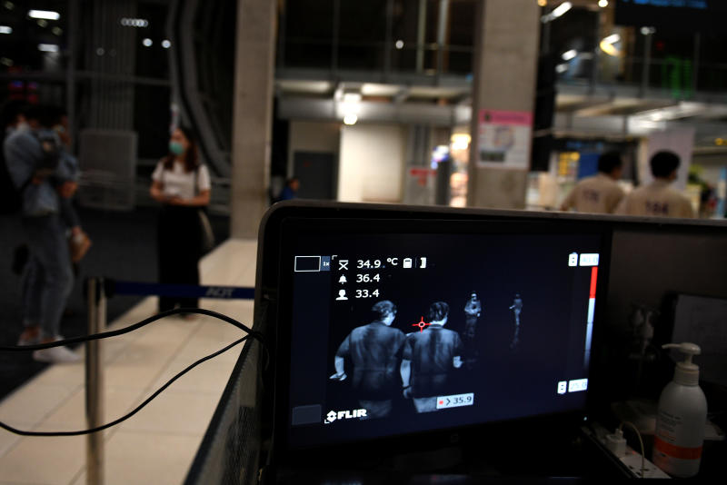 Passengers are seen on screen as they pass through a thermal scanner upon arriving at Suvarnabhumi airport on Feb 20. (Reuters photo)