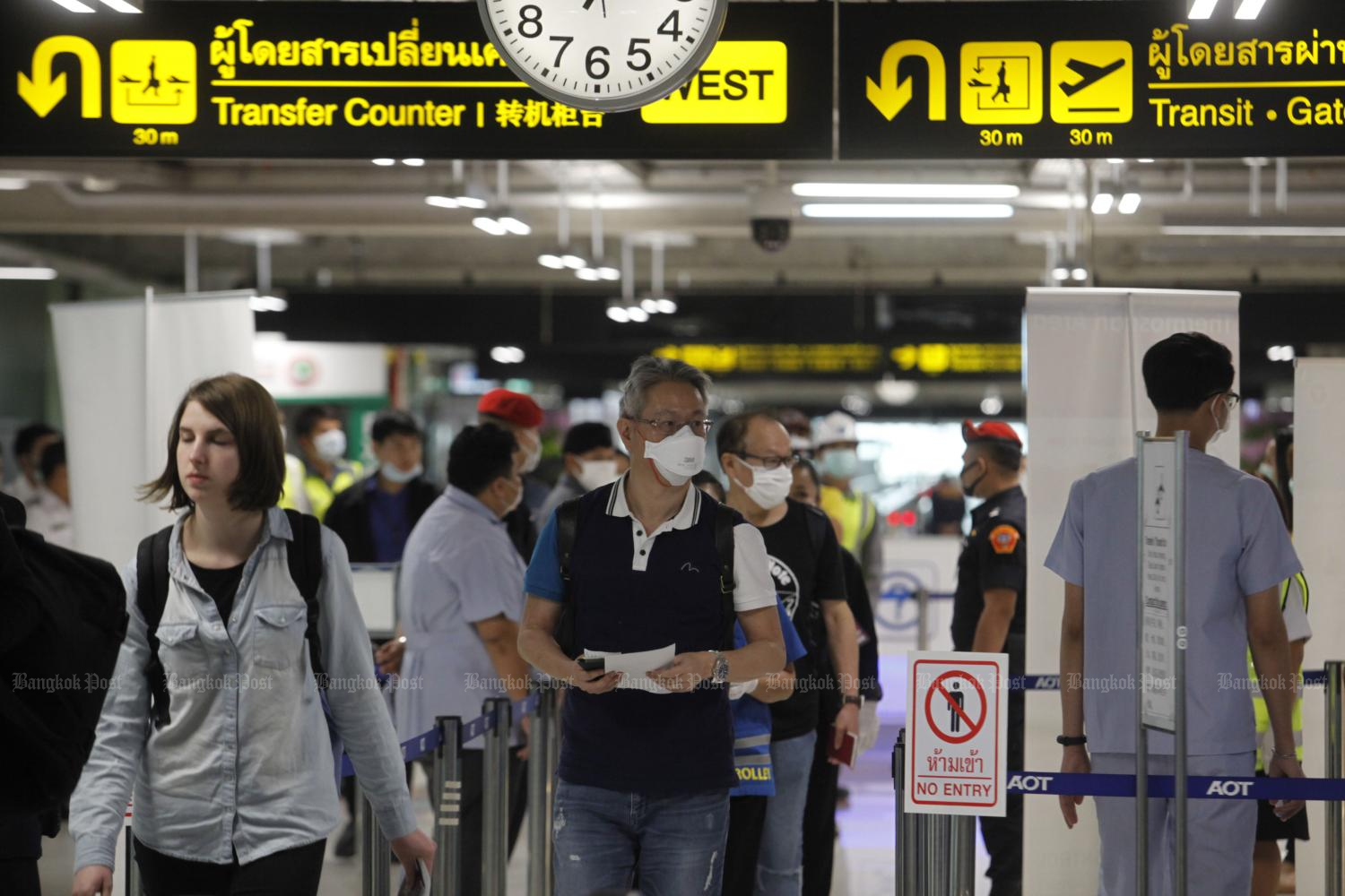 Passengers arriving from several countries including China pass a thermoscan machine at Suvarnabhumi airport as officials introduce precautionary measures against the spread of Covid-19. (Photo by Wichan Charoenkiatpakul)