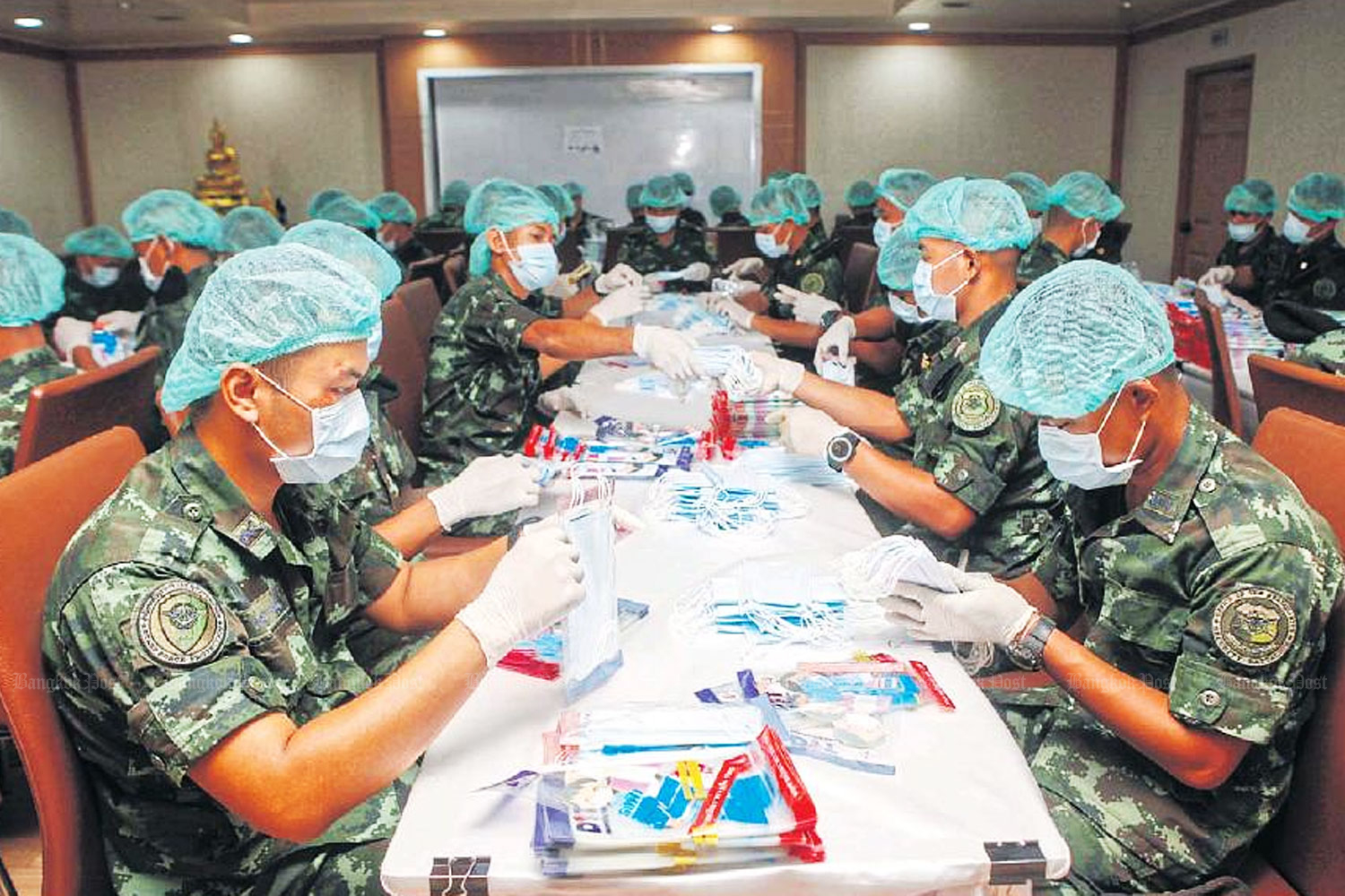 Soldiers pack surgical masks for distribution to hospitals courtrywide as part of a special mission at the Internal Trade Department, which is struggling to deal with a shortage. (Photo by Nutthawat Wicheanbut)