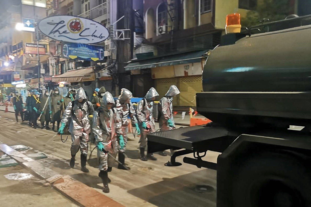 Soldiers wearing protective gear spray disinfectant in Bangkok on Thursday morning. (Royal Thai Army photo)