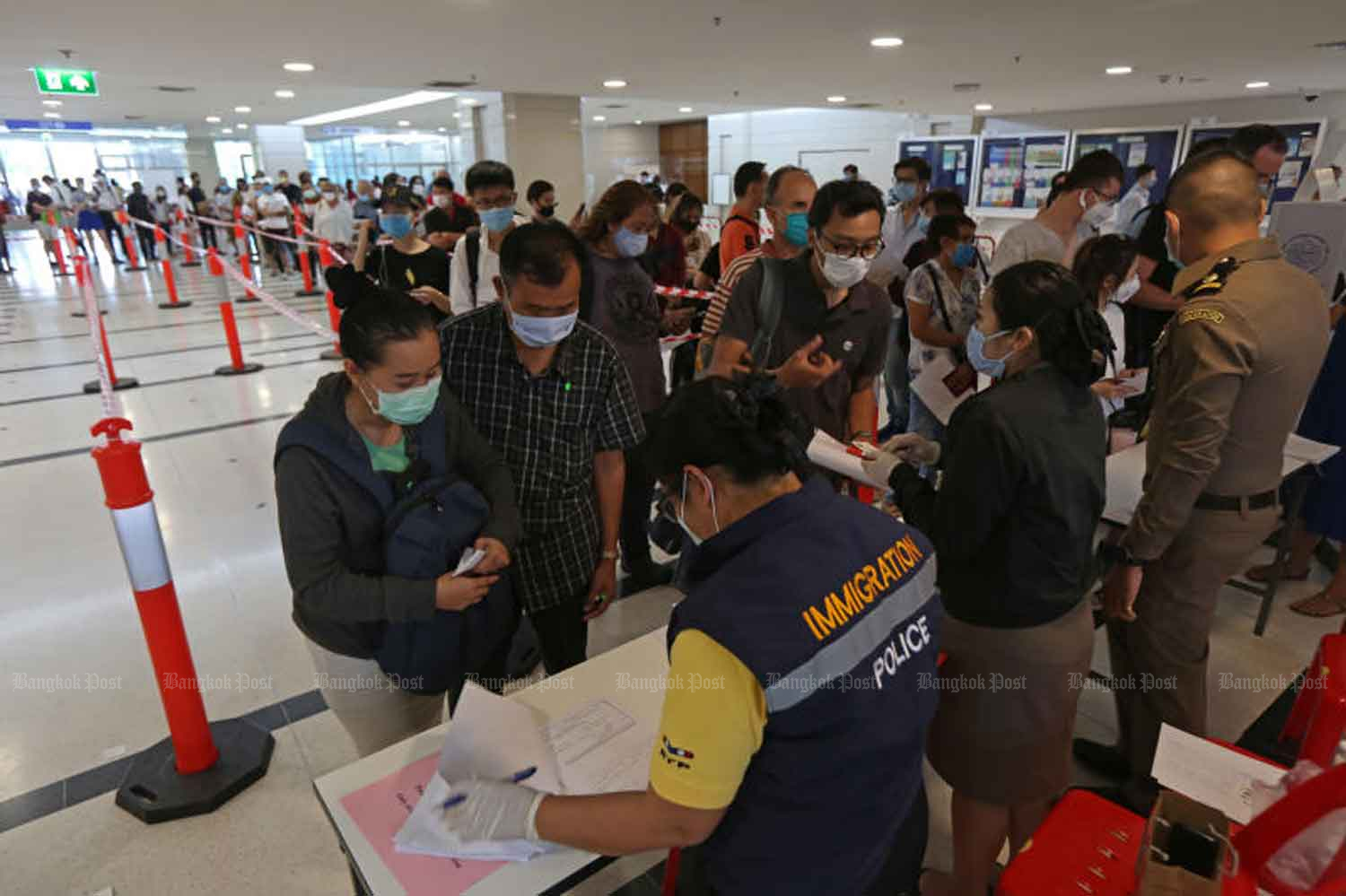 Foreigners report to the Immigration Bureau on Chaeng Watthana Road in Laksi district of Bangkok on Tuesday. (Photo: Varuth Hirunyatheb)