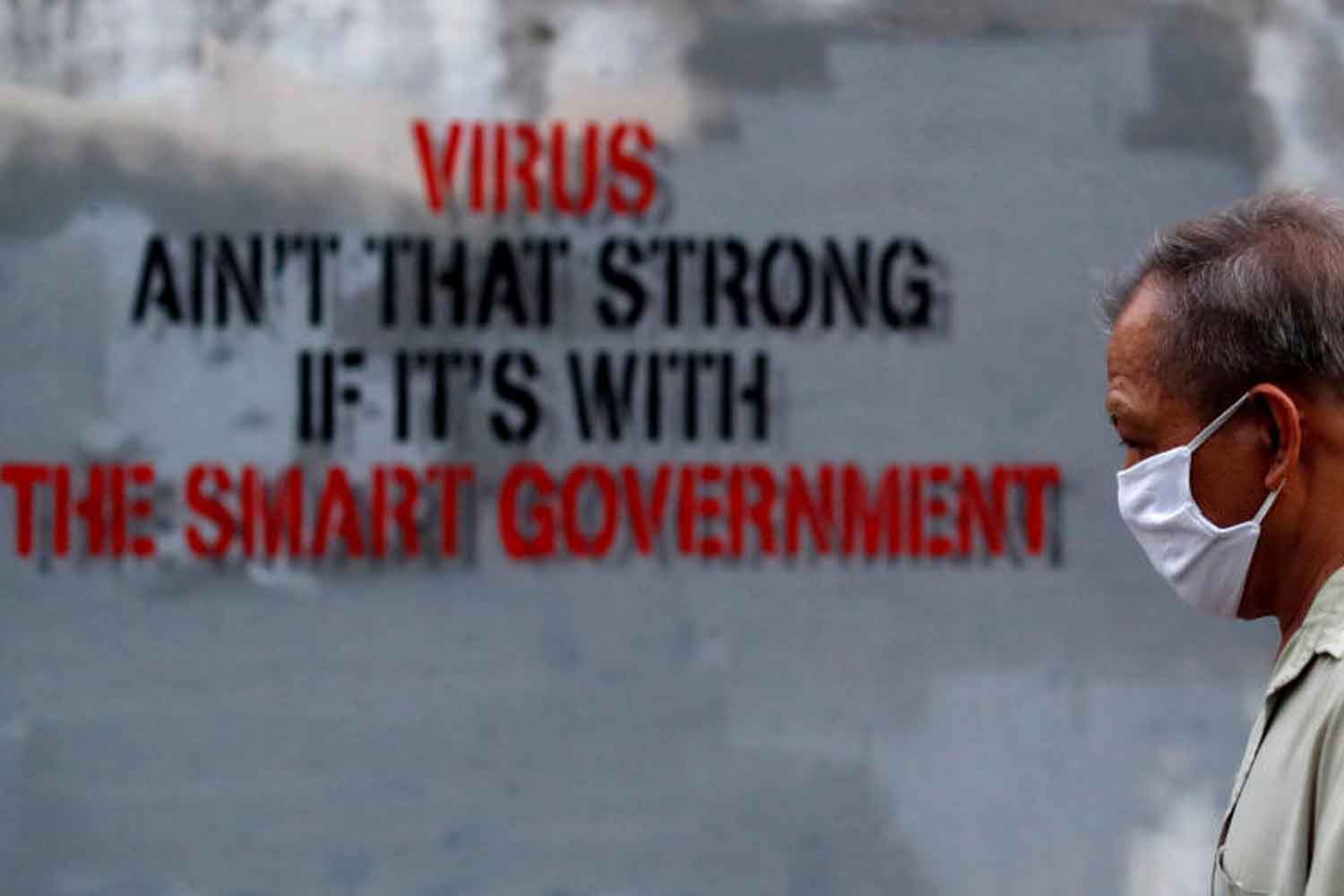 A man wearing a protective face mask walks a graffiti in a street amid the coronavirus disease (COVID-19) outbreak in Bangkok, Thailand March 26, 2020. (Reuters photo) A man wearing a protective face mask walks a graffiti in a street amid the coronavirus disease (COVID-19) outbreak in Bangkok, Thailand March 26, 2020. (Reuters photo)
