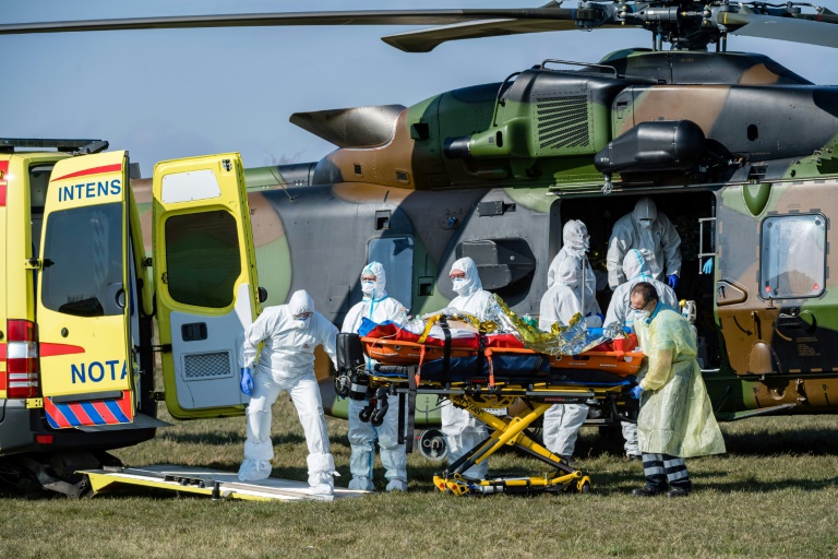 German medics take care of one of two French patients infected with the novel Covid-19 upon arrival at a little airport near Nordhausen/Harz. (Photo: AFP) German medics take care of one of two French patients infected with the novel Covid-19 upon arrival at a little airport near Nordhausen/Harz. (Photo: AFP)