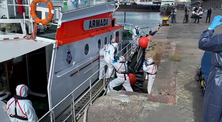 Medics help a sick passenger from an Australian liner off a Uruguay navy launch in Montevideo, on April 3, 2020. Medics help a sick passenger from an Australian liner off a Uruguay navy launch in Montevideo, on April 3, 2020.