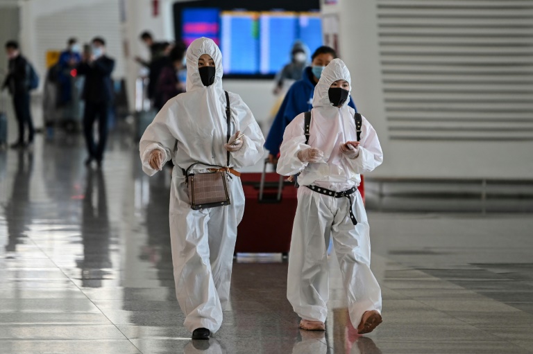 Passengers in protective gear walk through Tianhe Airport after it was reopened in Wuhan in China's central Hubei province Passengers in protective gear walk through Tianhe Airport after it was reopened in Wuhan in China's central Hubei province