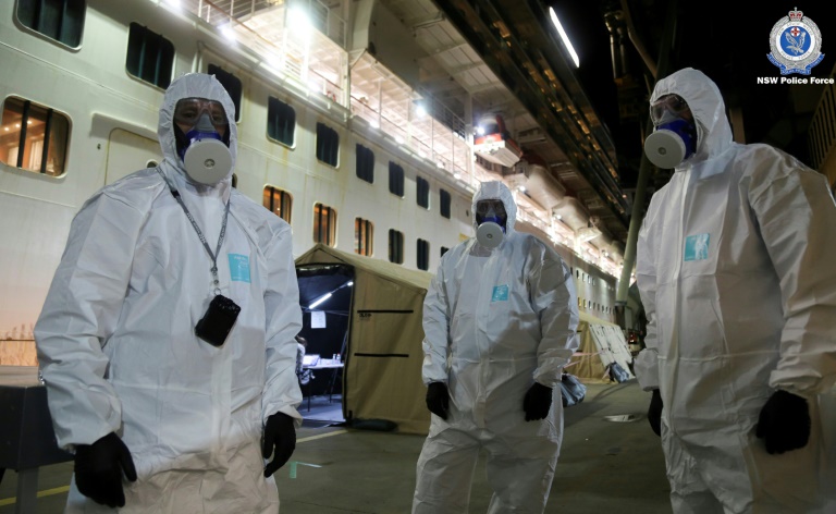 Police officers in protective gear prepare to board the coronavirus-stricken Ruby Princess cruise ship and seize its black box at Port Kembla, Australia. Police officers in protective gear prepare to board the coronavirus-stricken Ruby Princess cruise ship and seize its black box at Port Kembla, Australia.
