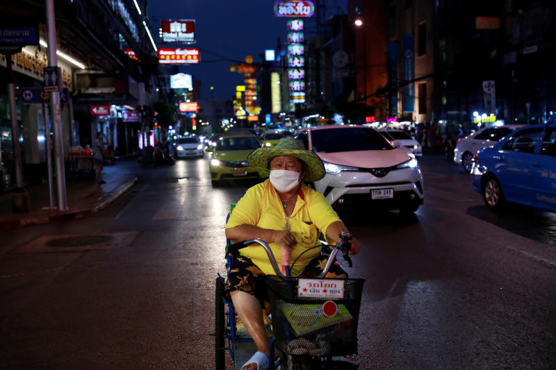 A woman wearing a protective face mask rides her cart during the coronavirus disease (Covid-19) outbreak in Bangkok on Saturday. (Reuters photo)