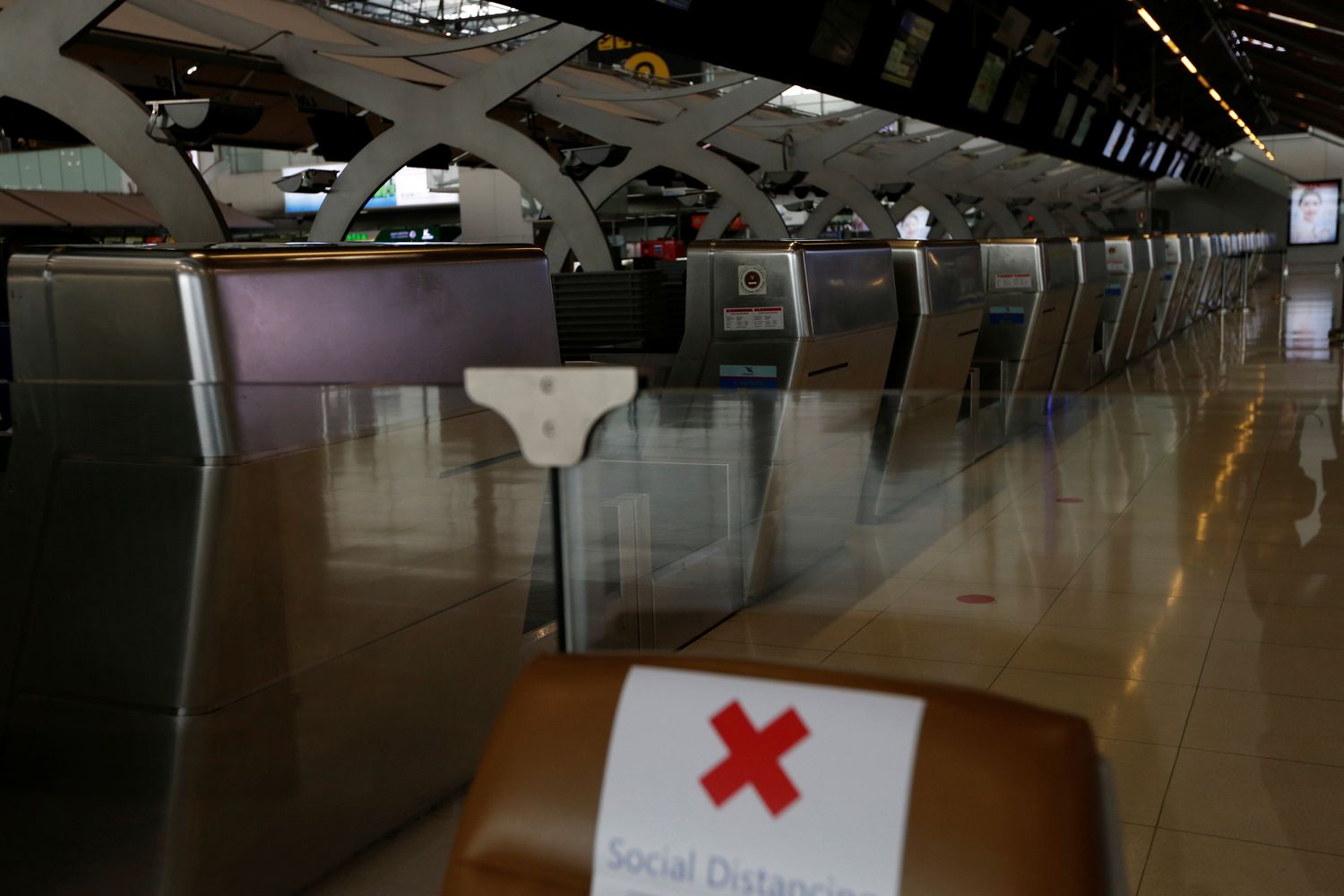 Empty check-in counters are seen at Suvarnabhumi airport on April 16 as the government extended a ban on incoming passenger flights until the end of the month. (Reuters photo)