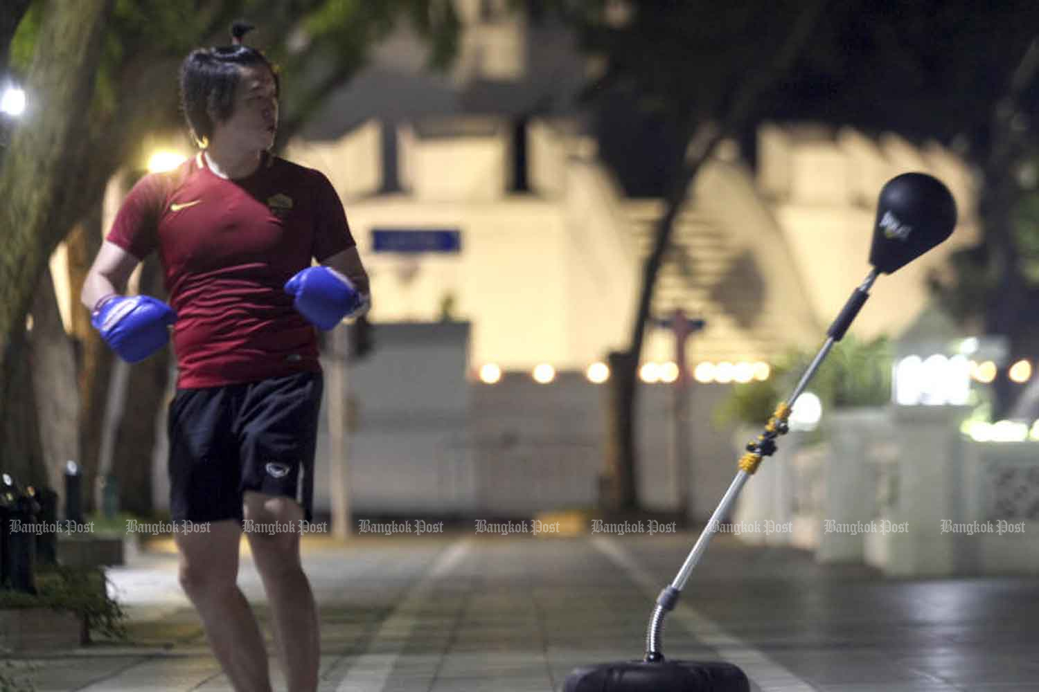 s boxing gyms have been closed to contain the spread of Covid-19, Prakit Choltanachaikul now practices near the Maha Jessadabodin on Ratchadamnoen Avenue for an hour before curfew begins at 10pm on Wednesday. (Photo by Arnun Chonmahatrakool)