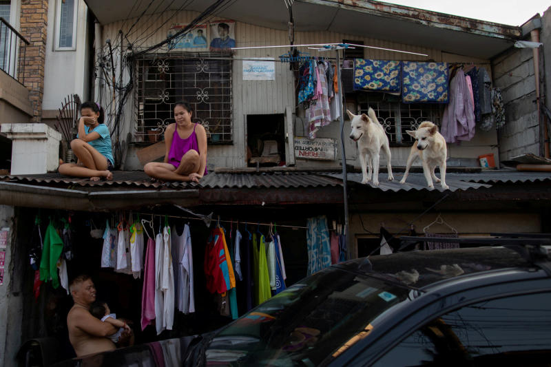 Girls hang out with their dogs on the roof of their house as the Philippine government enforces home quarantine to contain the coronavirus disease outbreak in Metro Manila on Tuesday. (Reuters photo)