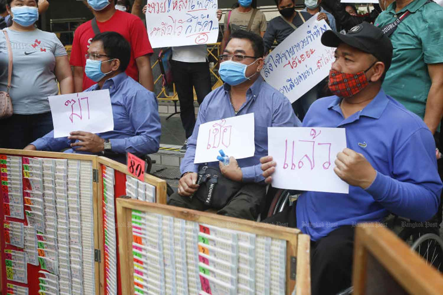 Disabled government lottery vendors gather at Government House in Bangkok on Tuesday to complain that they are not allowed to return to their points of sale at stores. (Photo: Pattarapong Chatpattarasill)