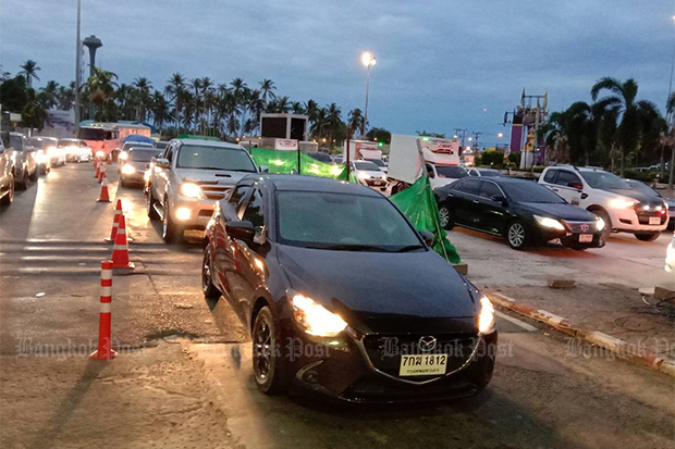 Motorists wait their turn to cross the bridge at Tha Chatchai and leave Phuket island for the southern mainland early on May 1, 2020. (Photo by Achadtaya Chuenniran)