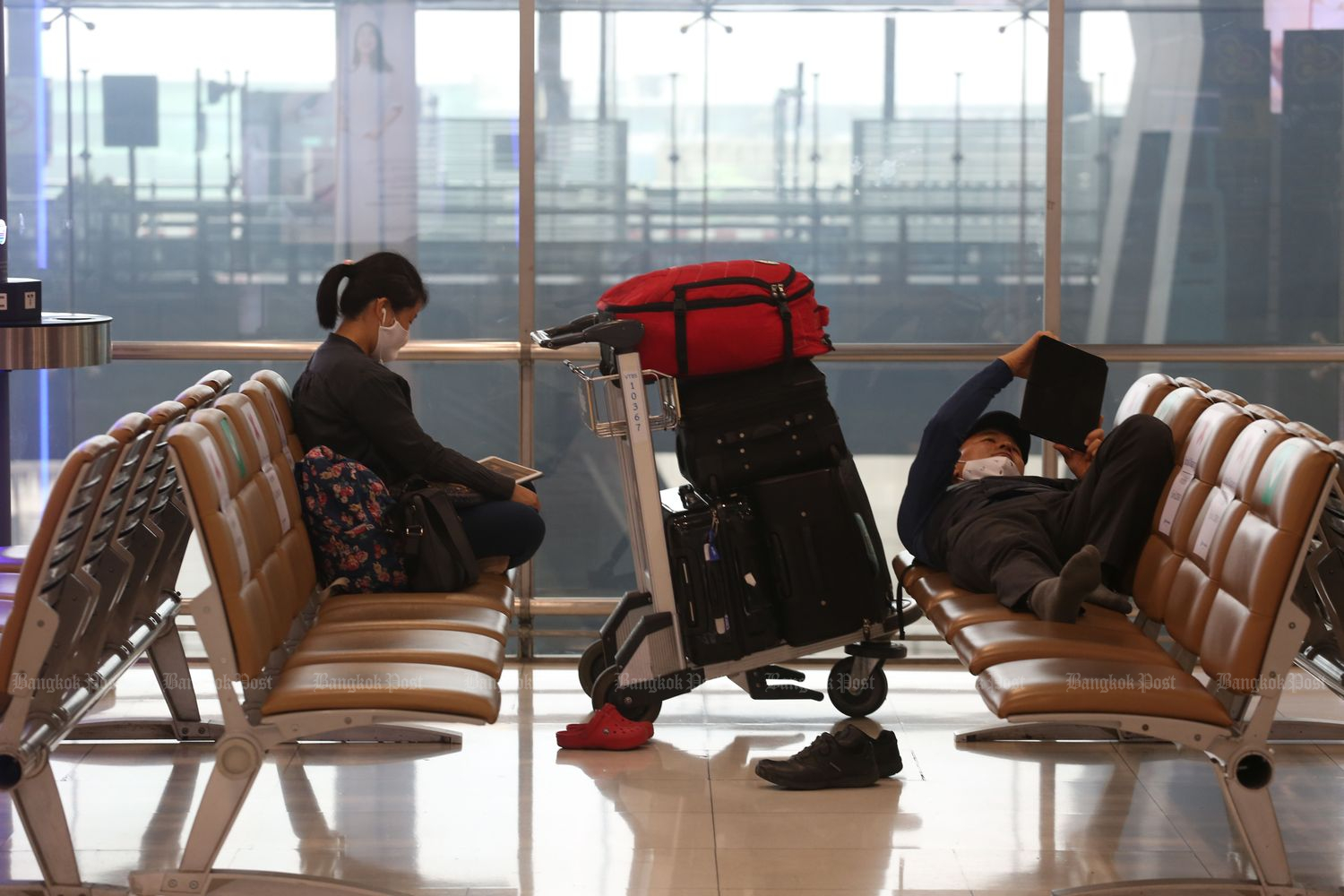 Passengers wait for a flight at Suvarnabhumi airport on Monday. (Photo by Varuth Hirunyatheb)