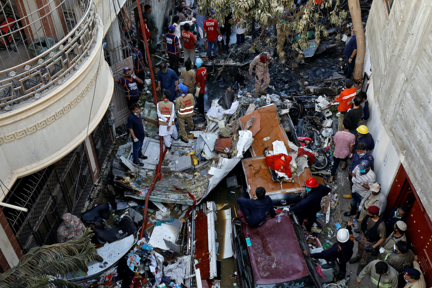 Rescue workers survey the wreckage of a passenger plane strewn along a residential street not far from the airport in Karachi, Pakistan on Friday. (Reuters Photo) Rescue workers survey the wreckage of a passenger plane strewn along a residential street not far from the airport in Karachi, Pakistan on Friday. (Reuters Photo)