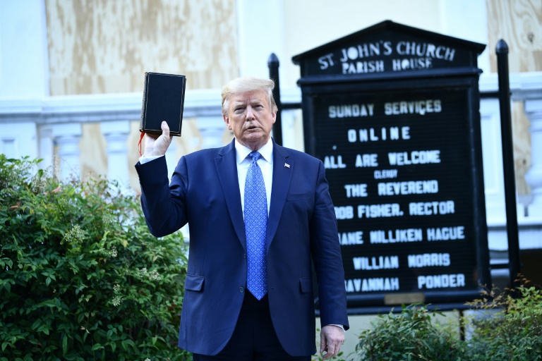 US President Donald Trump holds up a bible in front of St John's Episcopal church after walking across Lafayette Park from the White House in Washington, DC on June 1, 2020 US President Donald Trump holds up a bible in front of St John's Episcopal church after walking across Lafayette Park from the White House in Washington, DC on June 1, 2020