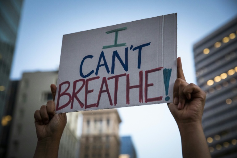 A demonstrator raises a sign during a protest against the death of George Floyd who died on May 25 in Minneapolis whilst in police custody, along a street in Oakland, California on June 3 A demonstrator raises a sign during a protest against the death of George Floyd who died on May 25 in Minneapolis whilst in police custody, along a street in Oakland, California on June 3