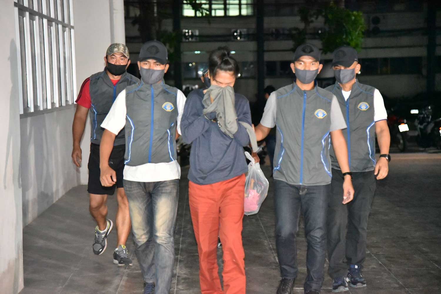 Thanphicha, aka "Mind", 28, is escorted by Crime Suppression Division police after she was arrested at a house near Victory Monument in Bangkok on Wednesday night on a charge  of stabbing her boyfriend to death. (Photo supplied)