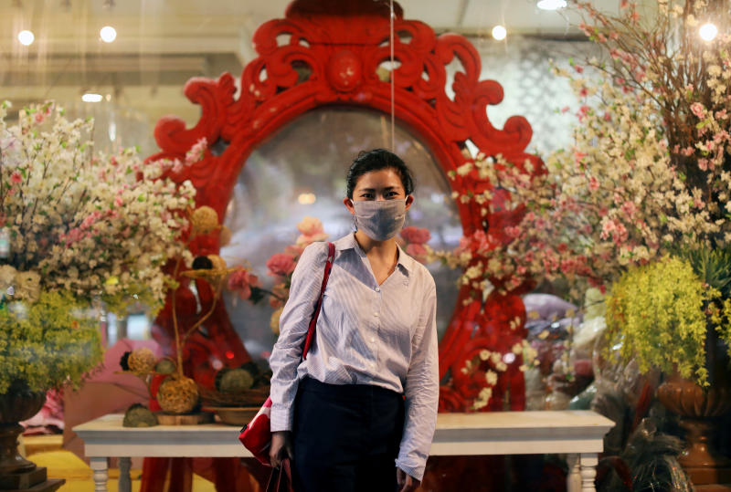 A woman wearing a protective mask poses in front of a flower shop, after the government eased some protective measures following the coronavirus disease (Covid-19) outbreak in Bangkok on Wednesday. (Reuters photo) A woman wearing a protective mask poses in front of a flower shop, after the government eased some protective measures following the coronavirus disease (Covid-19) outbreak in Bangkok on Wednesday. (Reuters photo)