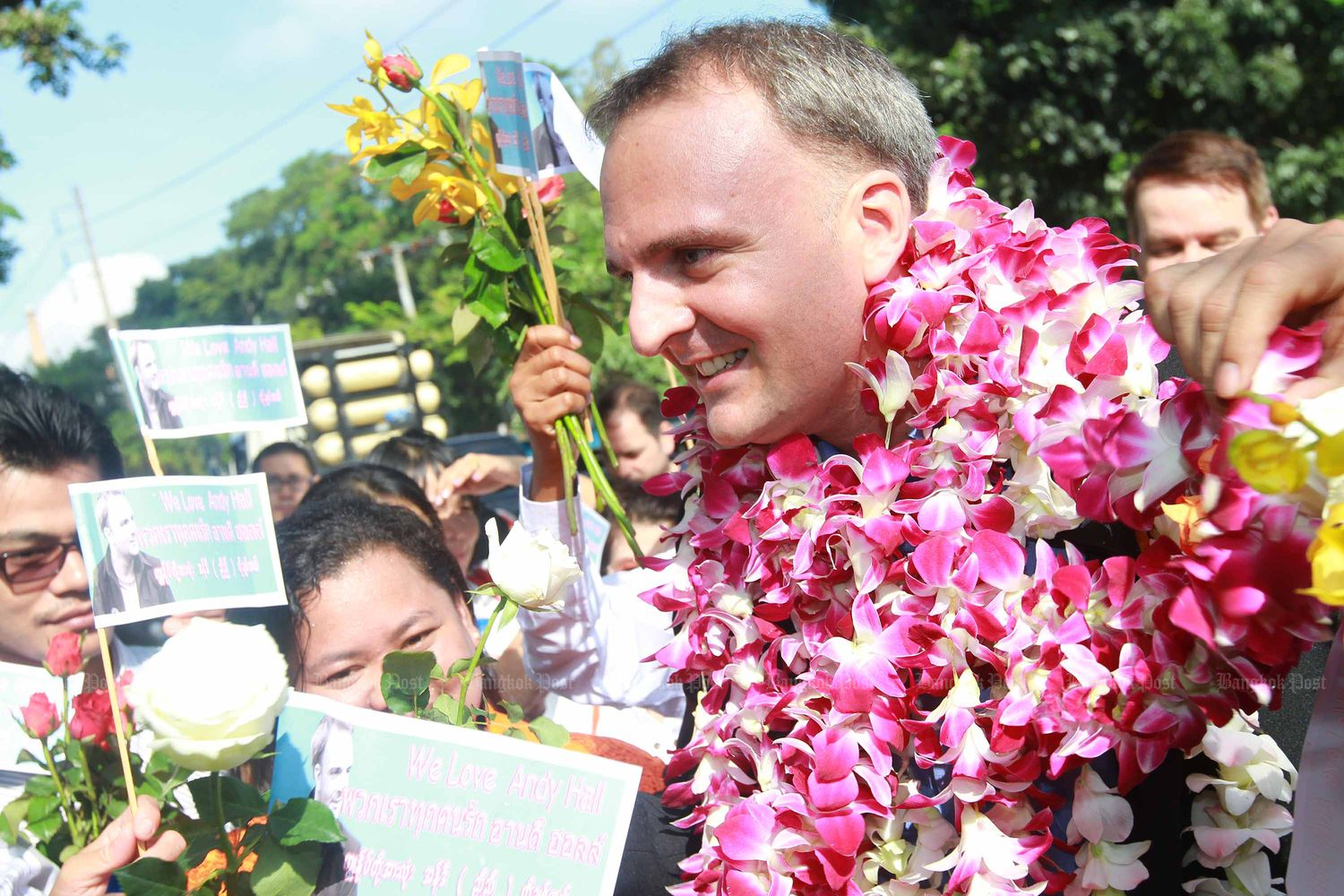 In this Oct 29, 2014 file photo, British human rights activist Andy Hall receives flowers from supporters as he turns up at the Phra Khanong Provincial Court. (Bangkok Post file photo)