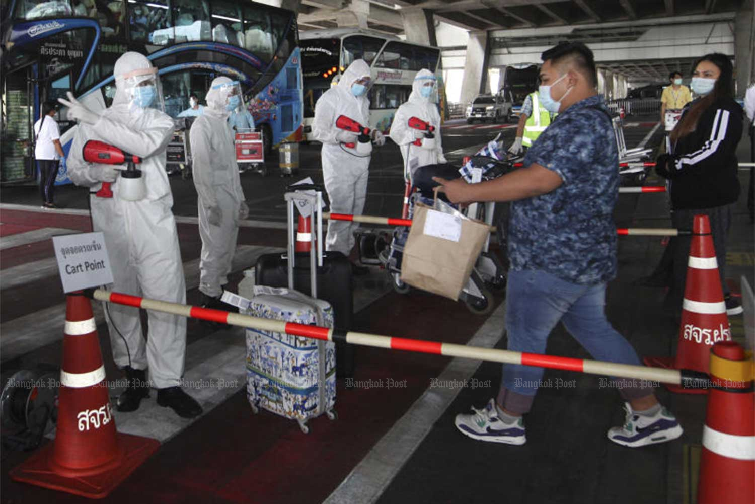 Another group of Thai returnees on July 9 are taken to state quarantine facilities. The government on Saturday reported 14 new Covid-19 cases, all returnees from Bahrain, the United States and Sudan. (Photo: Arnun Chonmahatrakool)