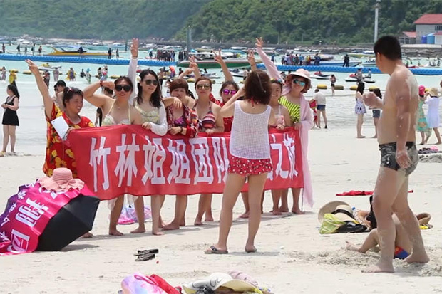 Chinese tourists enjoy the sand and surf on Koh Lan off Pattaya on June 8, 2018. (Post Today photo)