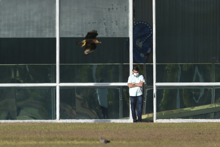 Brazilian President Jair Bolsonaro, standing outside the presidential palace in Brasilia, has tested positive for coronavirus a second time. Brazilian President Jair Bolsonaro, standing outside the presidential palace in Brasilia, has tested positive for coronavirus a second time.